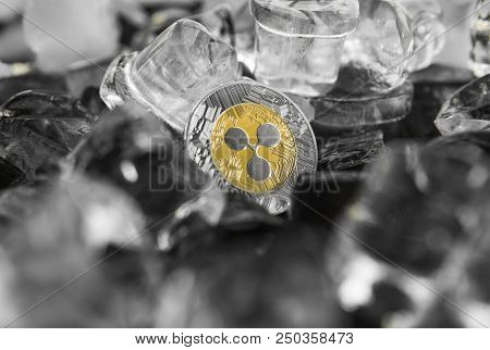 Gold Ripple Coin On Ice Background. The Concept Of The Exchange In Winter. Freeze. Blockchain Mining
