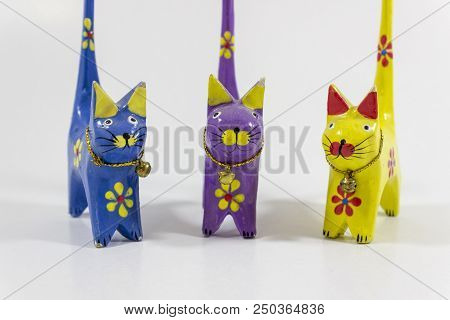 Close-up Shot Of Blue And Yellow Three Small Cat Figures Of Wooden Carved Nicknack