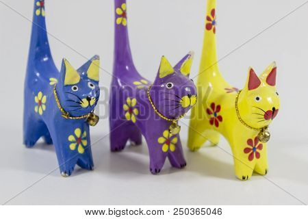 Perspective Shot Of Blue, Yellow And Purple Cat Figures Of Wooden Carved Nicknack