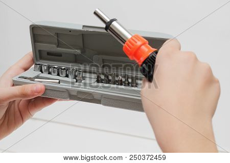 The Master Holds In His Hands A Screwdriver. Screwdriver Set In Box On White Background.
