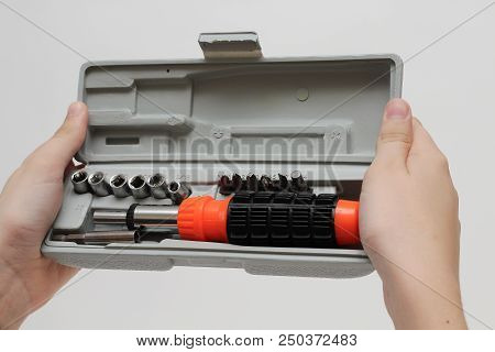 The Master Is Holding A Set Of Screwdrivers In A Box On A White Background.