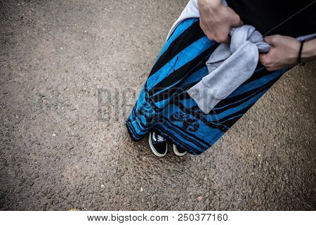 A Man In National Clothes Is Standing With His Hands On His Belt.