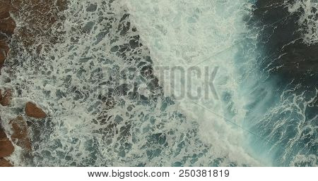 Aerial Photography. High Waves With White Crests Crashed Onto A Rocky Shore