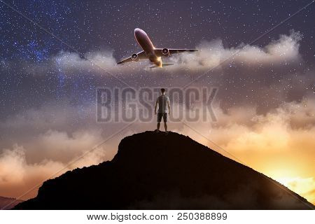 Travel Success Concept With Man Standing On Top Of The Rock At At Sunsut Sky Background With Airplan