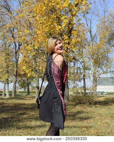 A Woman Is Posing In Front Of A Camera In An Autumn Park. Autumn Photo Shoot. Autumn In The Park.