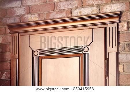 Element Of A Wooden Door Brown Colored Carved In Classical Geometric Style With Golden Hinges On Bri