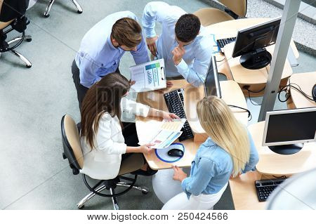 Top View Of Young Modern Colleagues In Smart Casual Wear Working Together While Spending Time In The