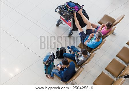 Bangkok, Thailand - 21 July 2018 - Four Tourists Wait Casually For Their Flights With Some Use Their