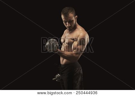 Athletic Young Man With Dumbbell On Black Background, Making Strenth Biceps Exercises. Naked Torso, 