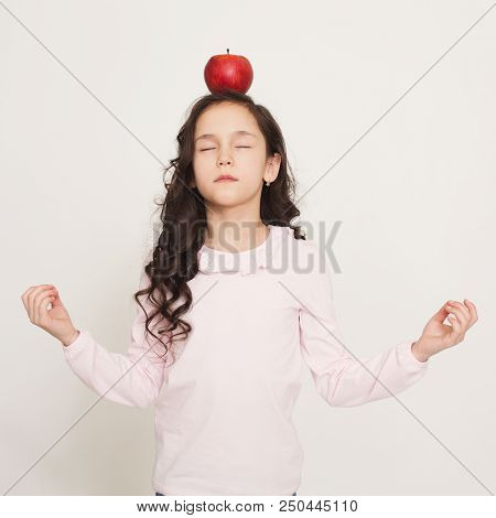 Fortitude Training. Little Girl Meditating With Apple On Her Head, Copy Space