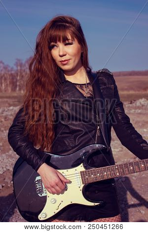 Beautiful Girl In Leather Jacket With Guitar