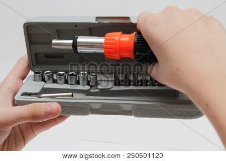 The Master Holds In His Hands A Screwdriver. Screwdriver Set In Box On White Background.