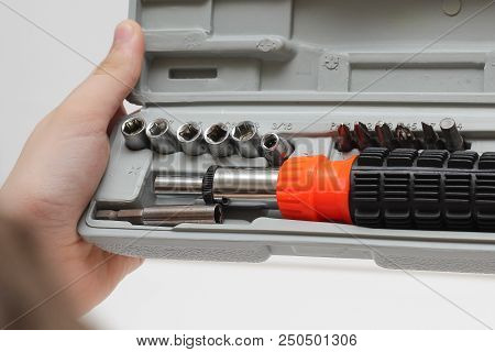 The Master Is Holding A Set Of Screwdrivers In A Box On A White Background.