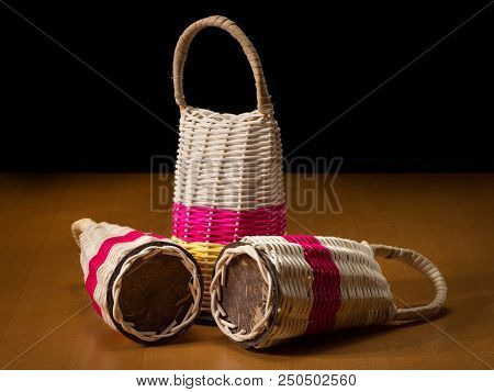 Three Colorful Caxixis Standing On A Wooden Table, Black Background