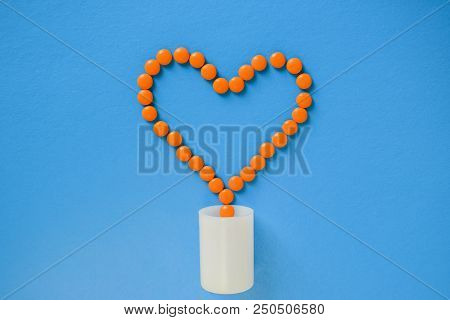 Orange Heart From Tablets And Pills On A Blue Background