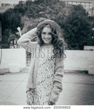A Beautiful Girl In A Hat, Keeps The Hair From The Wind. Sits On Scraps. Walk Around The City. Portr