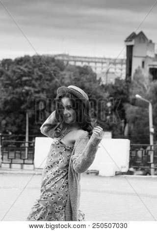 A Beautiful Girl In A Hat, Keeps The Hair From The Wind. Sits On Scraps. Walk Around The City. Portr