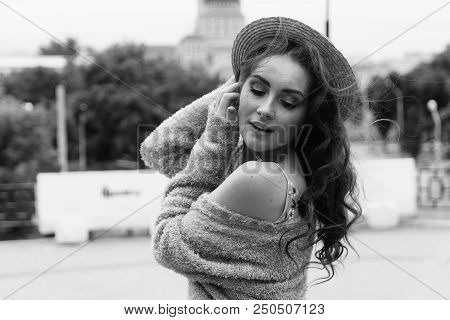 A Beautiful Girl In A Hat, Keeps The Hair From The Wind. Sits On Scraps. Walk Around The City. Portr