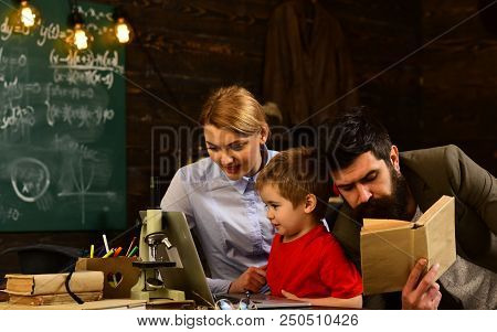 Pretty Teacher Helping Pupil In Classroom At The Elementary School, Tutor Asks The Tutee To Find The