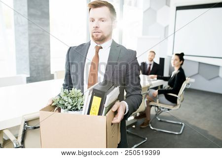 Waist Up Portrait Of Bearded Young Man Holding Box Of Personal Belongings And Leaving Office After B