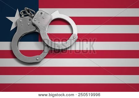 Liberia Flag  And Police Handcuffs. The Concept Of Crime And Offenses In The Country.
