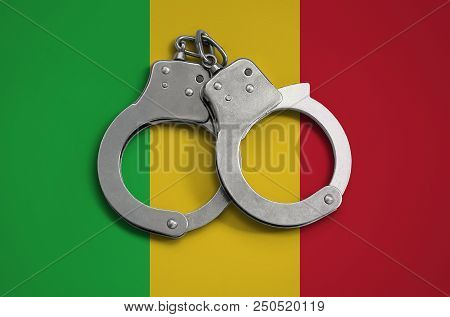Mali Flag  And Police Handcuffs. The Concept Of Observance Of The Law In The Country And Protection 