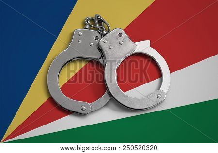 Seychelles Flag  And Police Handcuffs. The Concept Of Observance Of The Law In The Country And Prote