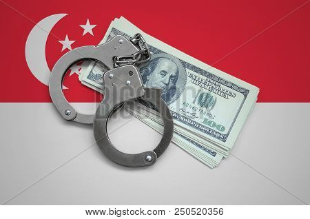 Singapore Flag  With Handcuffs And A Bundle Of Dollars. Currency Corruption In The Country. Financia
