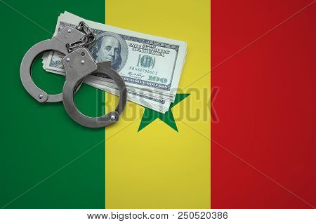 Senegal Flag  With Handcuffs And A Bundle Of Dollars. The Concept Of Breaking The Law And Thieves Cr