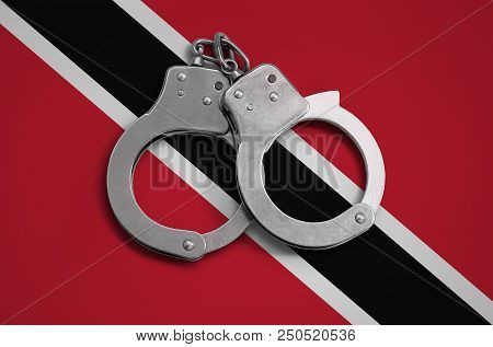 Trinidad And Tobago Flag  And Police Handcuffs. The Concept Of Observance Of The Law In The Country 
