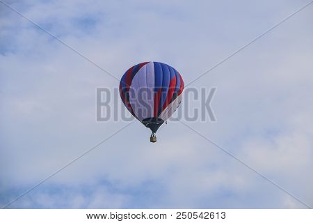 Colorful Hot Air Balloon Against Blue Sky. Hot Air Balloon Is Flying In White Clouds. Beautiful Flyi