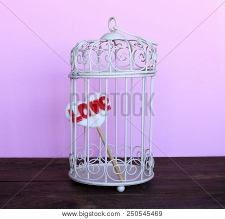 Heart In A Cage On A Pink Background. The Concept Of Love, Valentine's Day. Forced Love. Blind Love.
