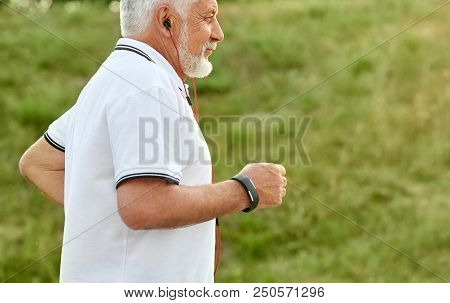 Cropped Photo Of Old Man Listening To Music While Running . Model Wearing White Polo Shirt With Dark