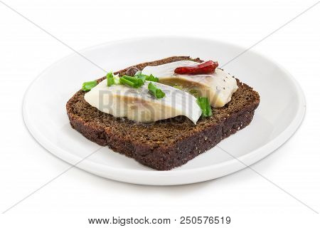 Open Sandwich Made Of Brown Bread, Slices Of Fillet Of Pickled Atlantic Herring, Hot Pepper And Gree