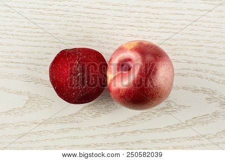 Group Of One Whole One Half Of Fresh Pluot Interspecific Plums Variety Flatlay On Grey Wood