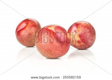 Group Of Three Whole Fresh Pluot Interspecific Plums Variety Isolated On White