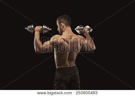 Athletic Young Man With Dumbbell On Black Background, Making Strenth Biceps Exercises. Naked Torso, 