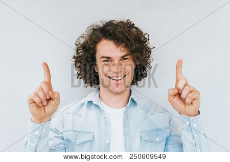 Portrait Of Curly Hair Amazed Handsome Man Has Happy Expression, Indicate Index Fingers Up, Good Ide