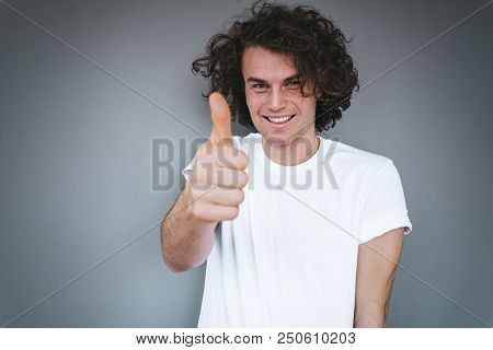 Portrait Of Handsome Male Smling With Healthy Toothy Smile, Wears White T-shirt Looking At The Camer