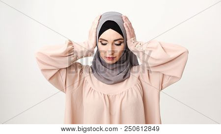 Hear No Evil. Arab Woman In Hijab Covering Ears At White Studio Background