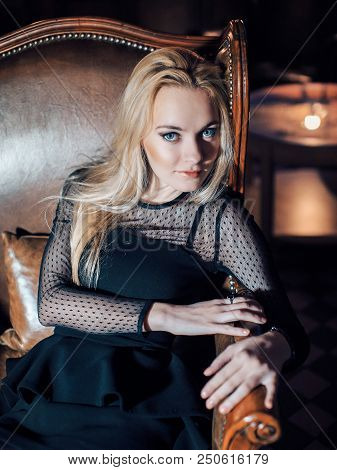 Portrait Of A Blue-eyed Blonde In Black Clothes. Beautiful Girl Looking At The Camera. Woman With Lo