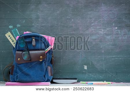 School Backpack And School Supplies With Chalkboard Background. Education Or Back To School Concept.