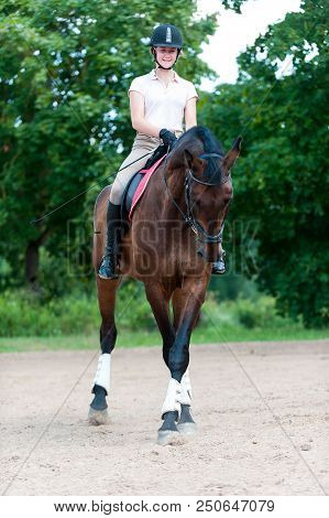 Teenage Girl Equestrian Riding Horseback On Arena At Sport Training Class. Vibrant Multicolored Outd