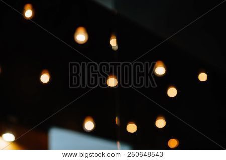 Burning Bulb Shines Weakly On The Background Blurred Yellow Lights
