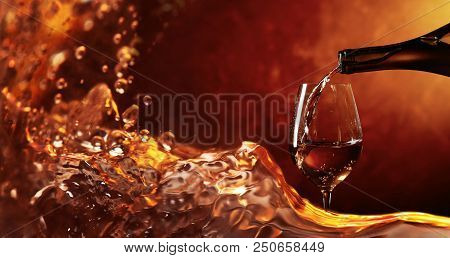 Conceptual Image On The Theme Of Winemaking. Wine Being Pouring Into A Glass. Closeup Wine Splashing