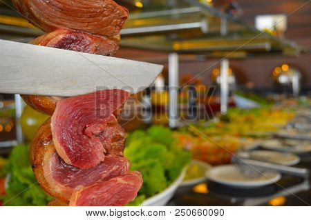 Pork Steak Undercooked Being Cut Into Rotisserie Of Prime Beef