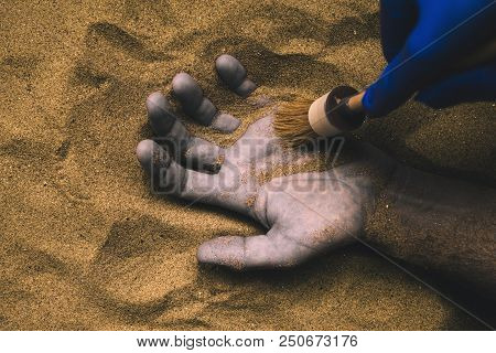 Forensic Expert Discovering Dead Body Buried In Desert Sand. Conceptual Image For Police Investigati