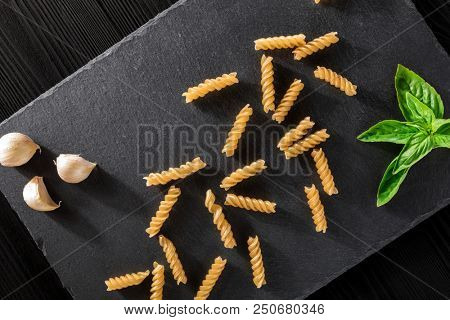 vermicelli Garlick fennel pepper of basilic on a black stone background