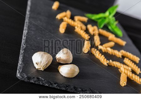 vermicelli Garlick fennel pepper of basilic on a black stone background