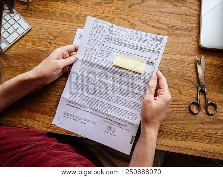 Paris, France - Jul 1, 2018: Woman Reading Letter Issued By Spanish Authorities From The Direcion Ge